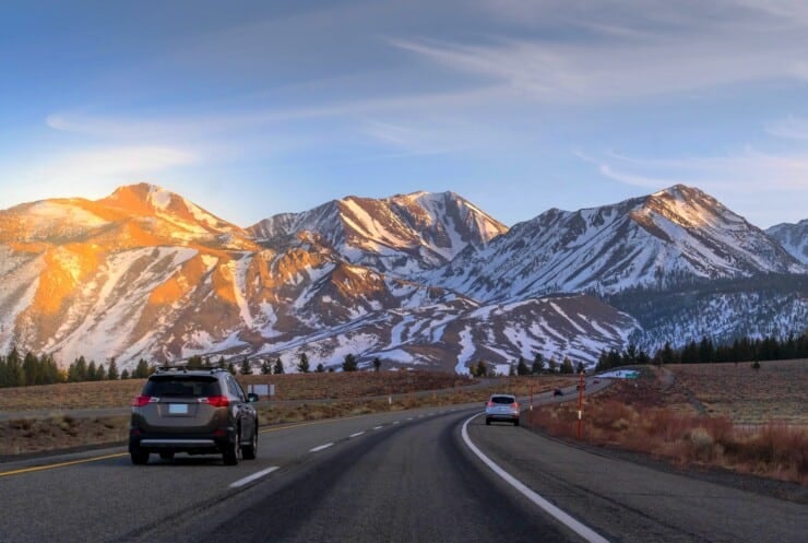 Sunset at Mammoth mountains and California Highway 395, leading to the snow-covered mountains range in winter, California, USA