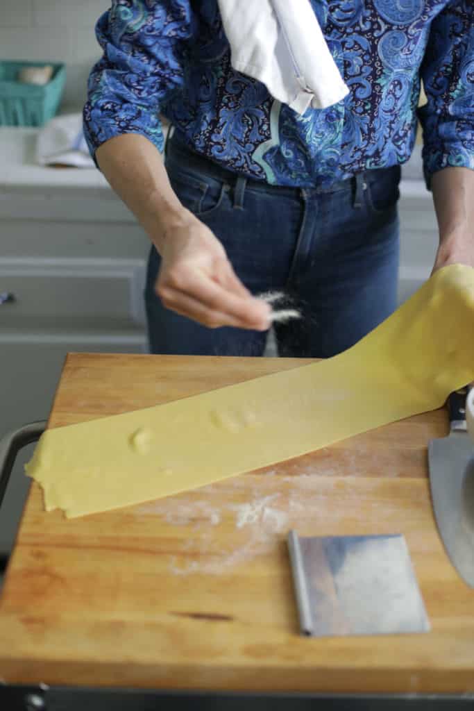 Dusting homemade Italian pasta dough sheets with semolina
