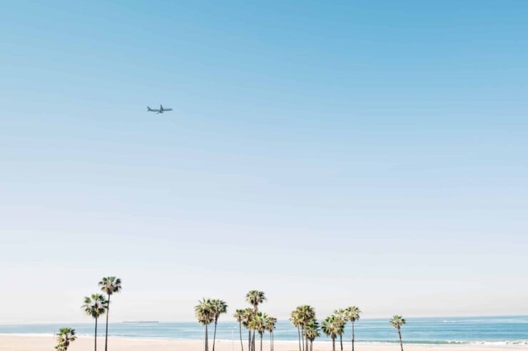 Airplane flying over beach in California