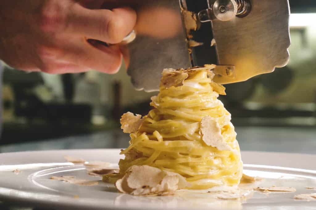 Pasta with white truffles being shaved over the top