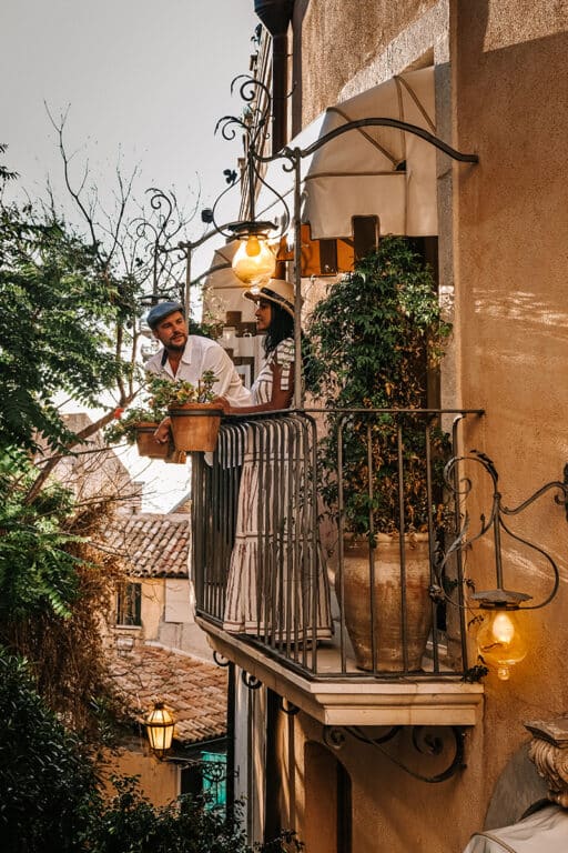 Couple on balcony of historic building overlooking trees in Taormina Sicily