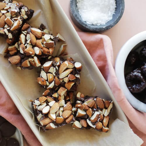 Nut Brownies In A Serving Platter With Prunes And Sea Salt In Dishes