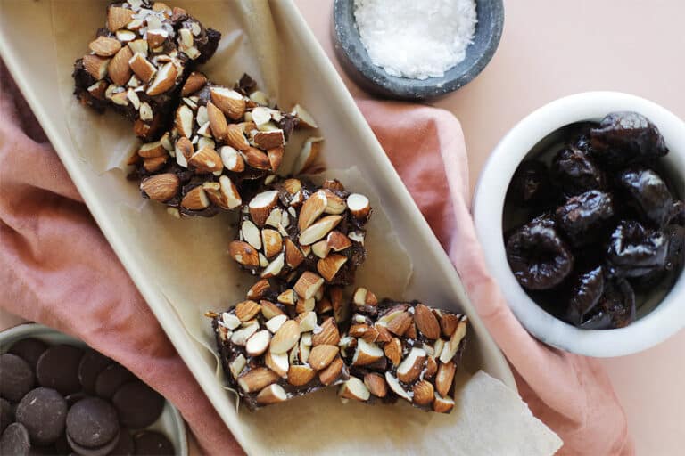 Nut Brownies In A Serving Platter With Prunes And Sea Salt In Dishes
