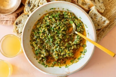 Serving plate of garlicky herbed olive dip with spoon