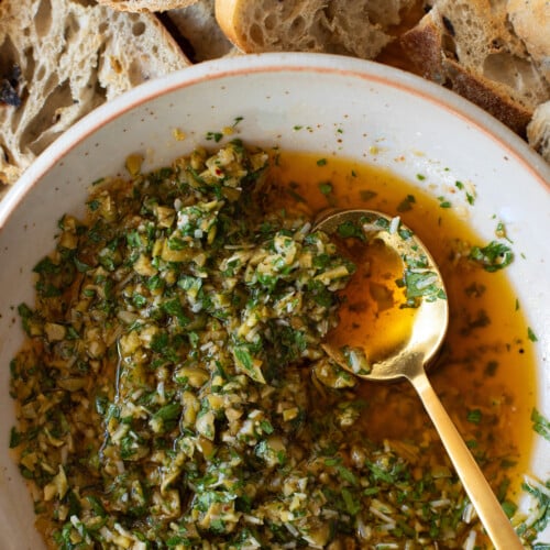 Close up bowl of Olive Dip with spoon in serving bowl