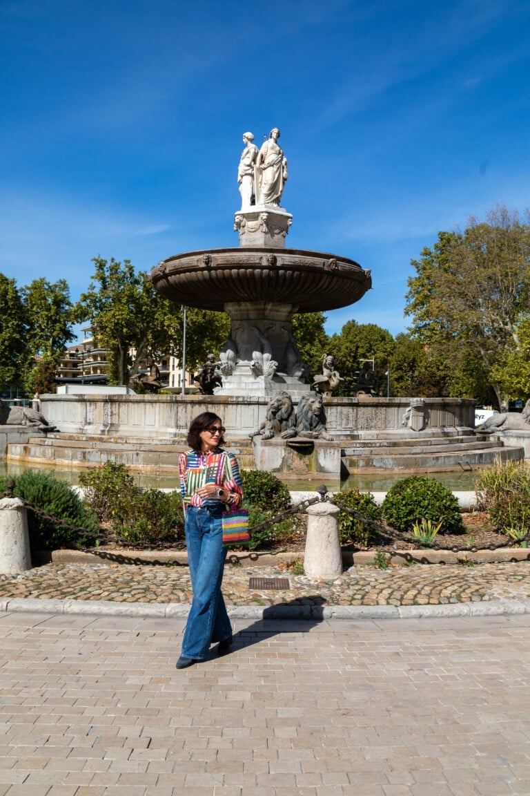 Woman standing next to a fountain Fontaine des Mars in Aix-en-Provence