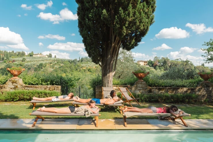 Group of teenage friends lounging on a lazy afternoon hanging out by a pool in Tuscany, Italy