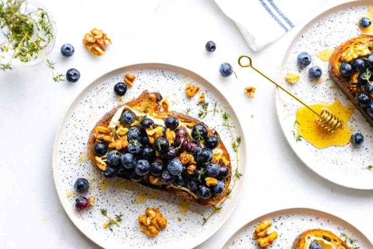 Toast with blueberries, brie, and nuts on a plate