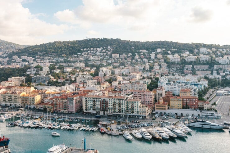 Aerial shot of port with boats and colorful buildings behind