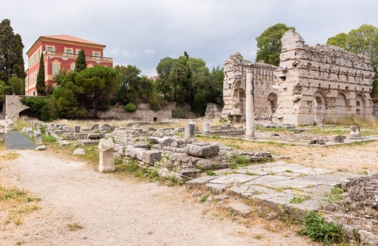 Roman ruins with a building in the back