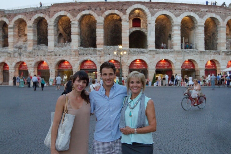 Two women and a man standing in front of an ancient arena in Verona Italy at sunset