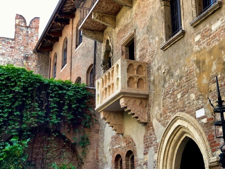 Frescoed palazzo and balcony above a leafy Renaissance courtyard in central Verona